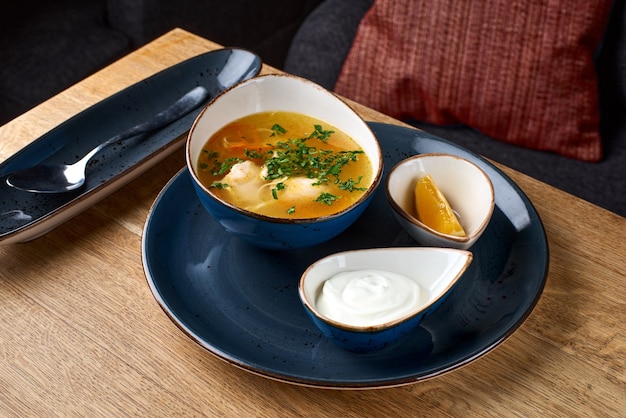 Soupe au poulet avec des nouilles aux œufs sur une table en bois.