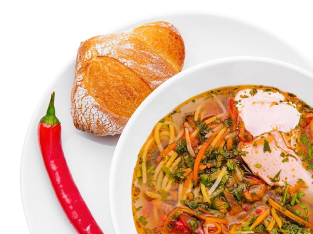 Soupe au poulet avec nouilles et légumes dans un bol blanc