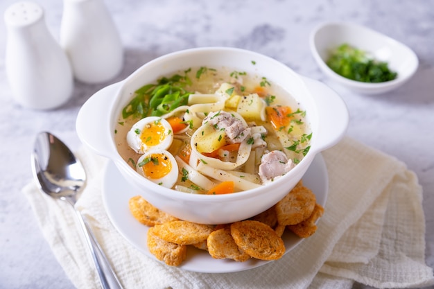 Soupe au poulet, nouilles, pommes de terre, œufs de caille et carottes