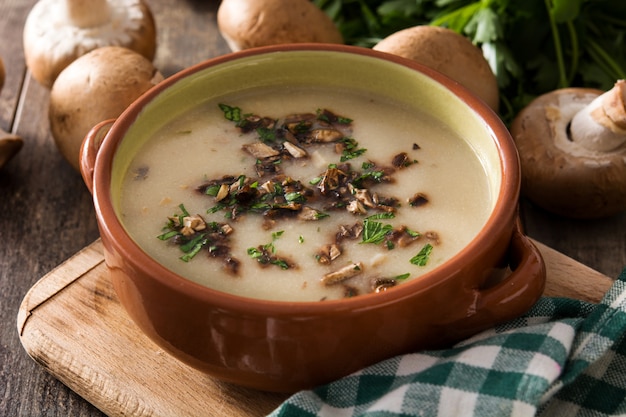 Soupe aux champignons maison dans un bol sur la table en bois.