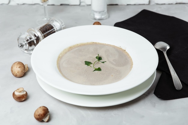 Soupe aux champignons et persil sur fond gris