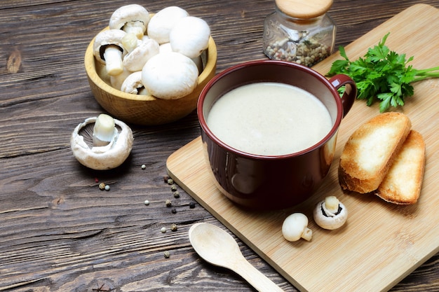 Soupe aux champignons purée de champignon dans une tasse brune sur une table en bois
