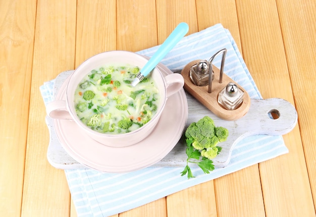 Soupe aux choux dans une assiette sur une serviette à bord pour couper sur une table en bois