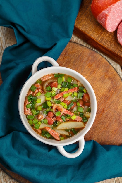 Soupe aux haricots juive avec viandes fumées dans une soupière photo horizontale