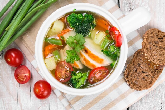 Soupe aux légumes avec bol en céramique blanche au poulet