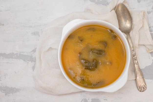 Soupe aux légumes avec craquelins dans un bol blanc sur céramique