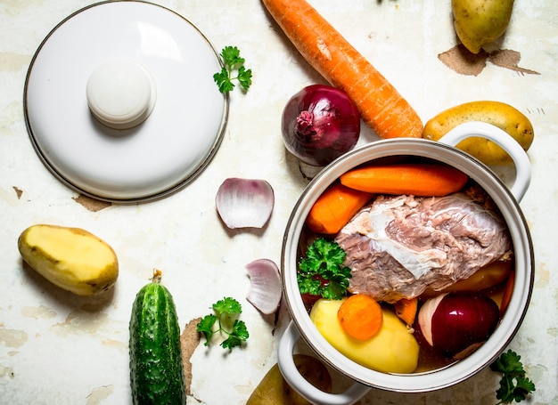 Soupe aux légumes, porc, épices et herbes dans une casserole