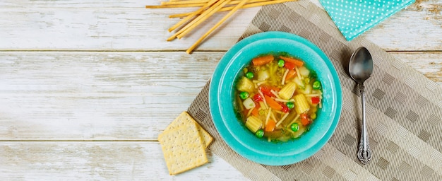 Soupe aux légumes saine avec des craquelins et des bâtonnets de pain.