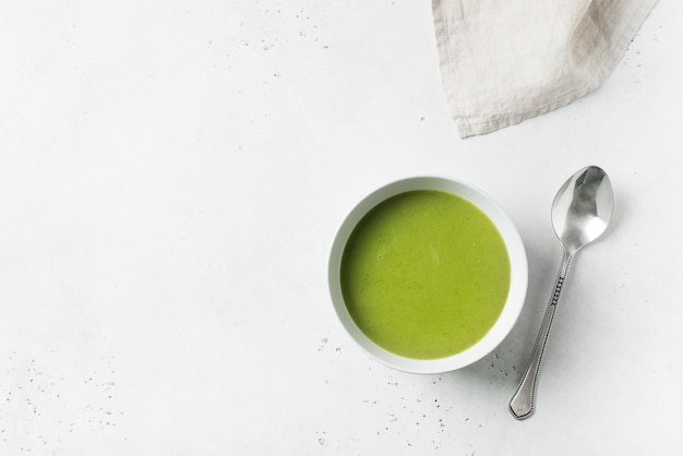 Soupe aux légumes verts sur blanc, vue du dessus