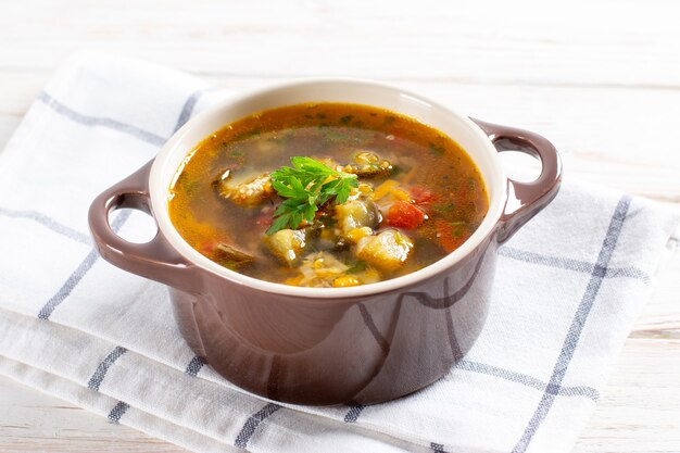 Soupe aux lentilles et légumes sur une table lumineuse.