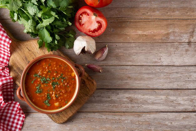 Soupe aux lentilles rouges dans un bol sur une table en bois rustique