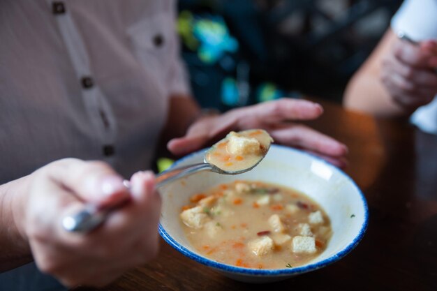 Soupe aux pois avec des craquelins de style rustique Femme mangeant de la soupe