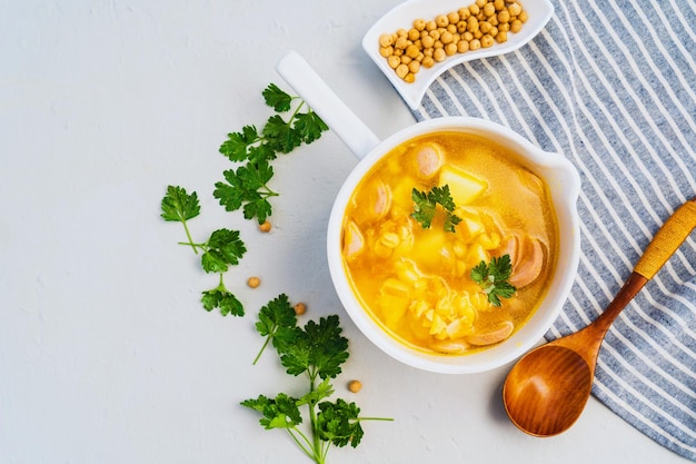 Soupe aux pois savoureuse traditionnelle avec saucisse fumée servie dans un bol blanc