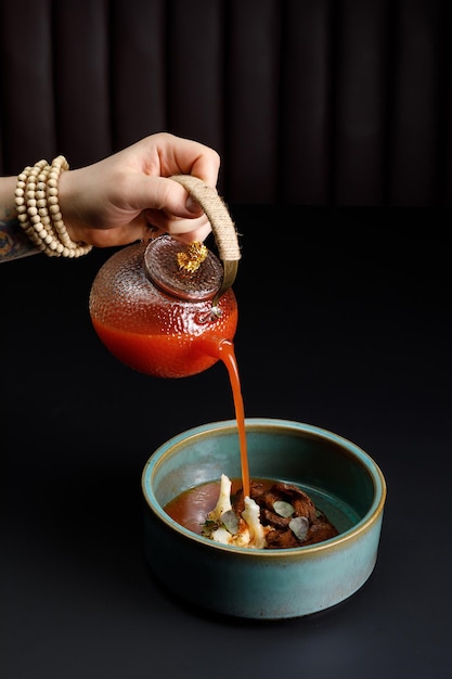 Soupe aux tomates avec boeuf grillé et légumes sur fond noir