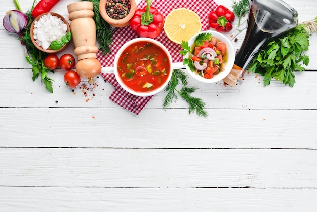 Soupe aux tomates avec concombre à l'oignon et paprika Vue de dessus Sur un fond en bois blanc Espace libre pour le texte