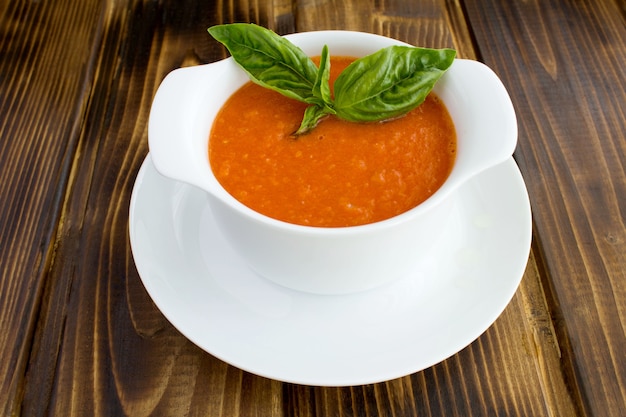 Soupe aux tomates dans le bol blanc gros plan