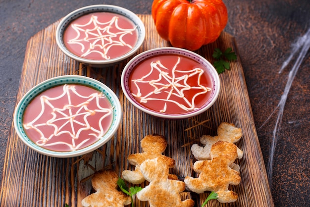 Soupe aux tomates et pain en forme d'hommes. Friandises d'Halloween pour la fête.