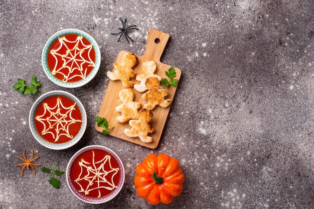 Soupe aux tomates et pain en forme d'hommes. Friandises d'Halloween pour la fête.