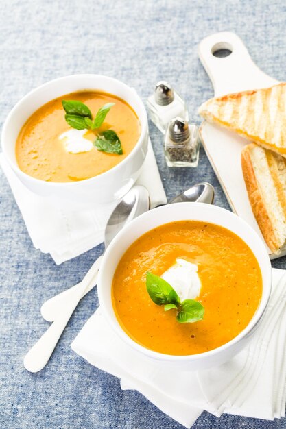 Soupe aux tomates rôties cuite avec des tomates anciennes biologiques et servie avec un sandwich au fromage grillé.