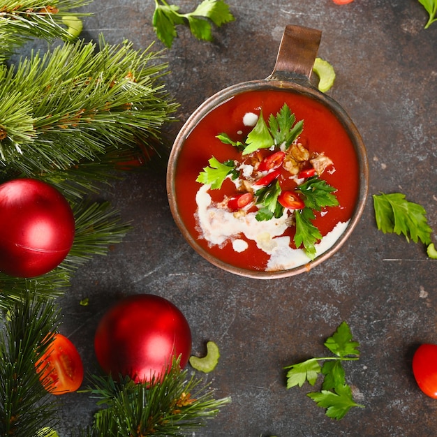 Soupe aux tomates rouges dans une tasse de cuivre sur fond sombre