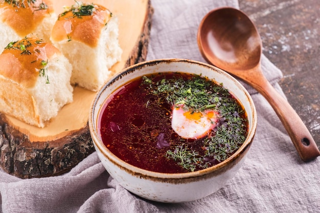 Soupe de betterave bortsch chaude rouge russe traditionnelle avec de la crème sure et des petits pains