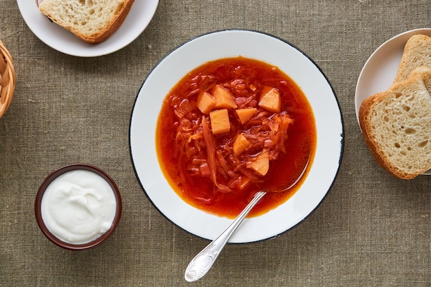 Soupe de betteraves aux légumes dans un bol blanc sur un fond textile