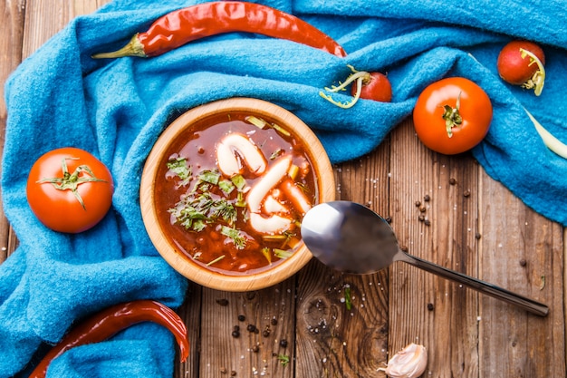 Soupe de betteraves dans une assiette en bois avec des légumes