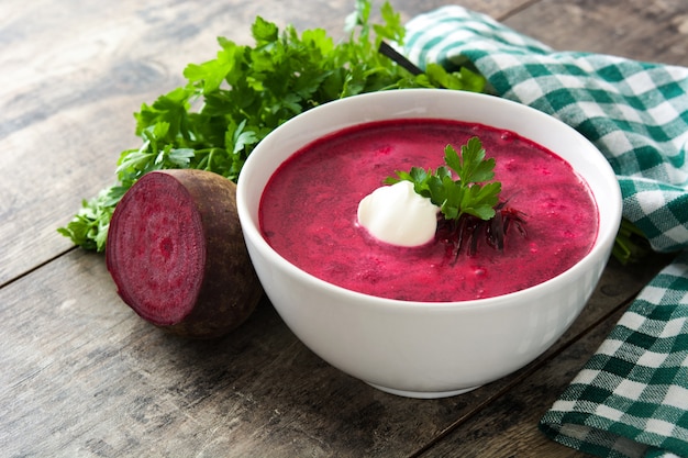 Soupe de betteraves dans un bol blanc sur une table en bois