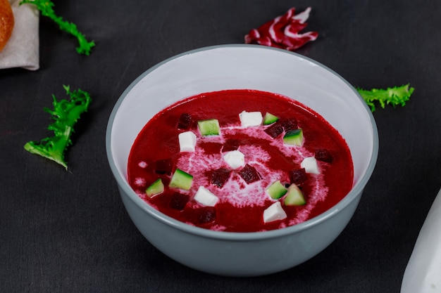 Soupe de betteraves maison avec du pain sur fond en bois