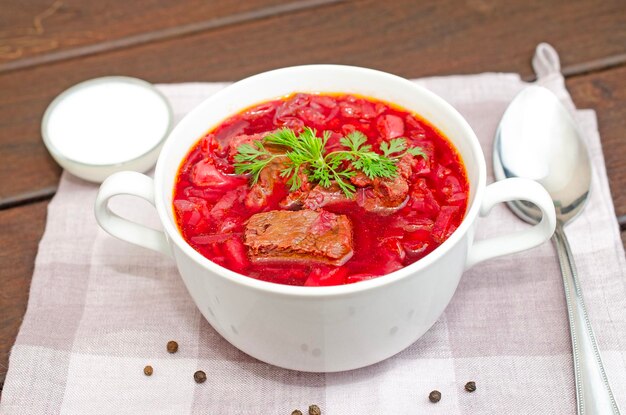 Soupe de borscht avec des légumes et de la viande sur une table en bois