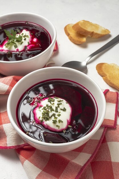 Soupe de bortsch rouge nationale ukrainienne et russe traditionnelle dans un bol avec de la crème sure et des herbes Concept d'aliments sains