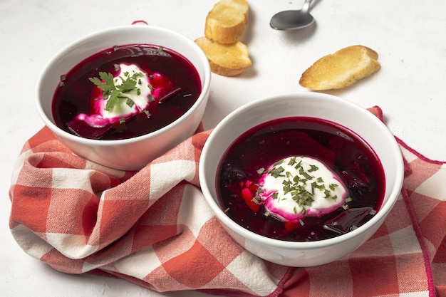 Soupe de bortsch rouge nationale ukrainienne et russe traditionnelle dans un bol avec de la crème sure et des herbes Concept d'aliments sains