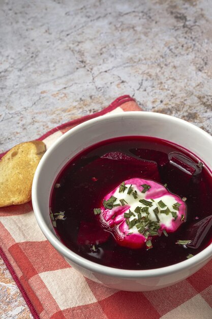 Soupe de bortsch rouge nationale ukrainienne et russe traditionnelle dans un bol avec de la crème sure et des herbes Concept d'aliments sains