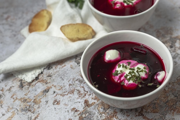 Soupe de bortsch rouge nationale ukrainienne et russe traditionnelle dans un bol avec de la crème sure et des herbes Concept d'aliments sains