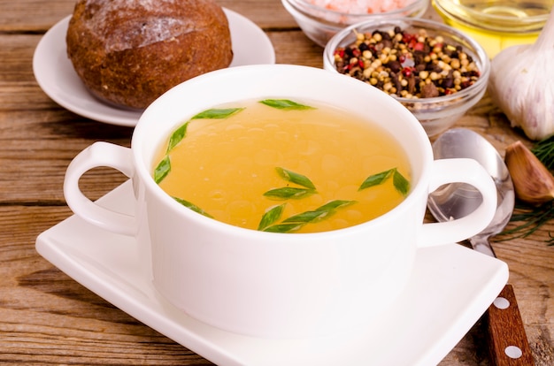 Soupe de bouillon de poulet dans une assiette blanche.