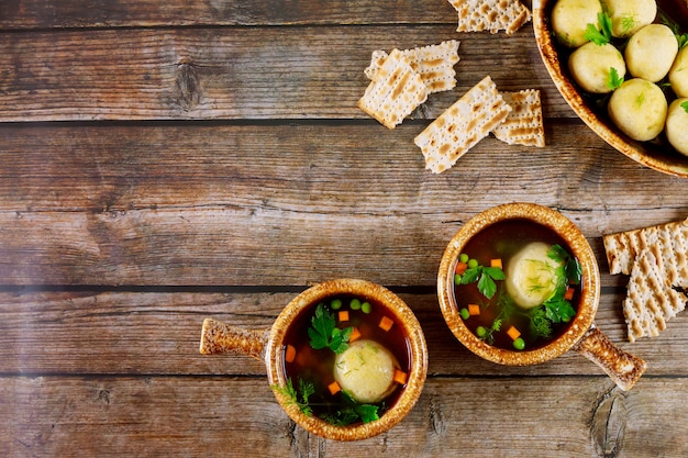 Soupe de boule de pain azyme dans deux assiettes avec des cuillères sur fond de bois.