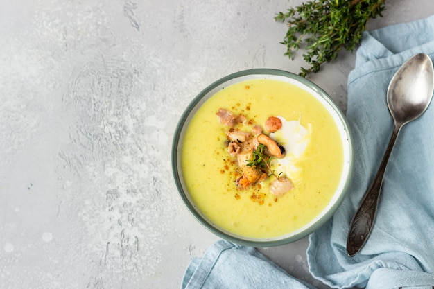 Soupe de chaudrée laiteuse épaisse aux fruits de mer servie avec crème sure, thym et poivre