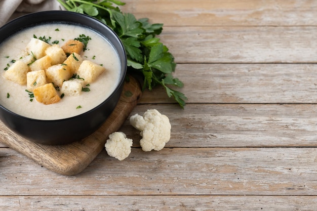 Soupe de chou-fleur dans un bol sur une table en bois