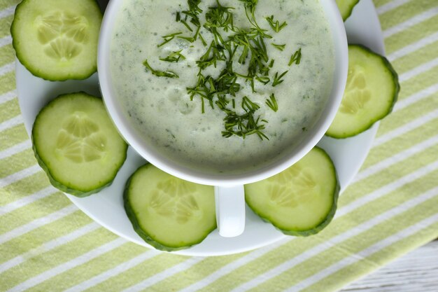 Soupe de concombre dans un bol sur fond de table en bois de couleur