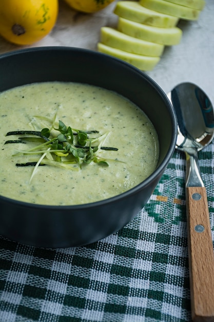 Soupe de courgettes garnie d'herbes.