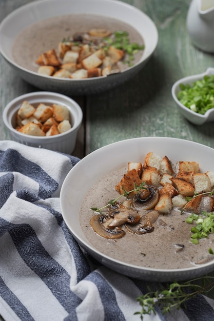 Soupe à la crème aux champignons et croûtons dans un bol blanc