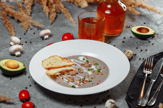 Soupe à la crème aux champignons et ingrédients sur fond gris en gros plan