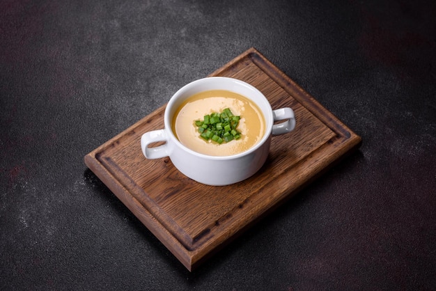 Soupe à la crème aux poireaux de pommes de terre et petits pois sur une table en béton foncé