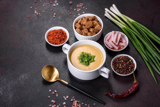 Soupe à la crème aux poireaux de pommes de terre et petits pois sur une table en béton foncé