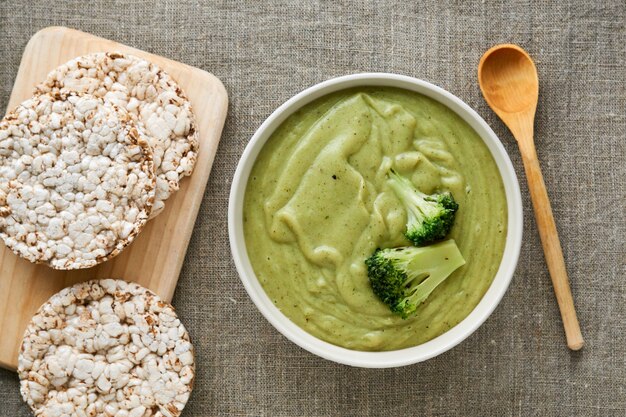 Soupe à la crème de brocoli dans un bol blanc sur un fond textile