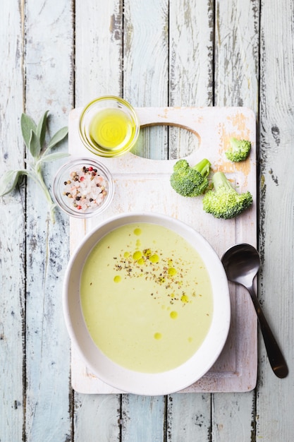 Soupe à la crème de brocoli dans un bol blanc sur la vue de dessus de fond en bois