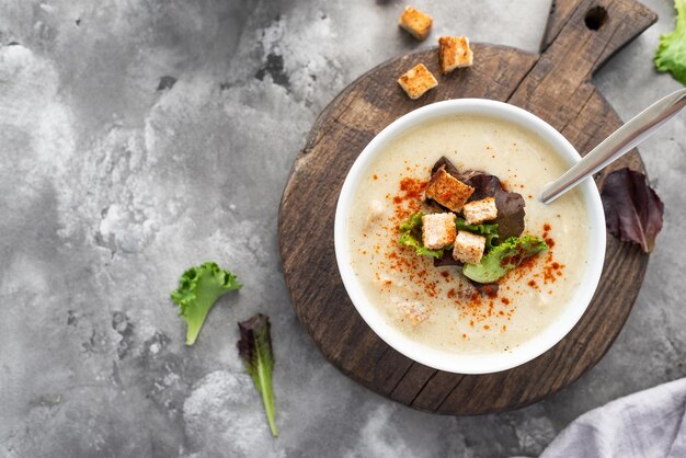 Soupe à la crème de champignons avec croûtons servis sur fond de béton Soupe dans un bol Vue de dessus