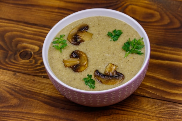 Soupe à la crème de champignons sur une table en bois