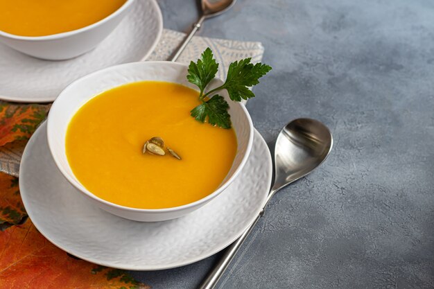 Soupe à la crème de citrouille fraîche dans un bol blanc