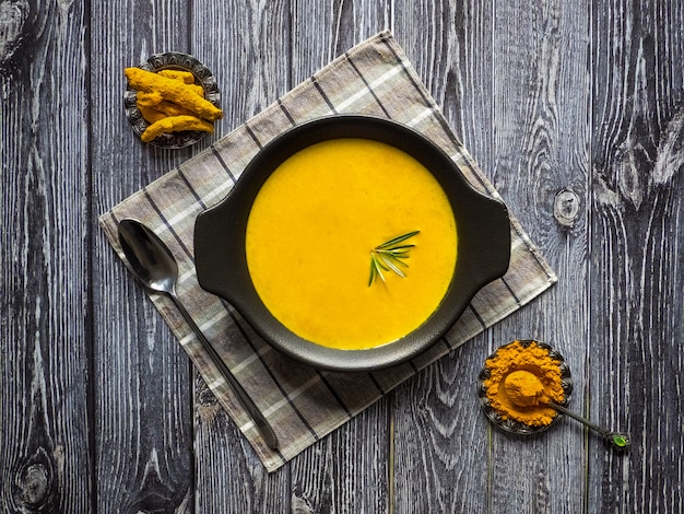 Soupe à la crème de curcuma sain sur bois noir